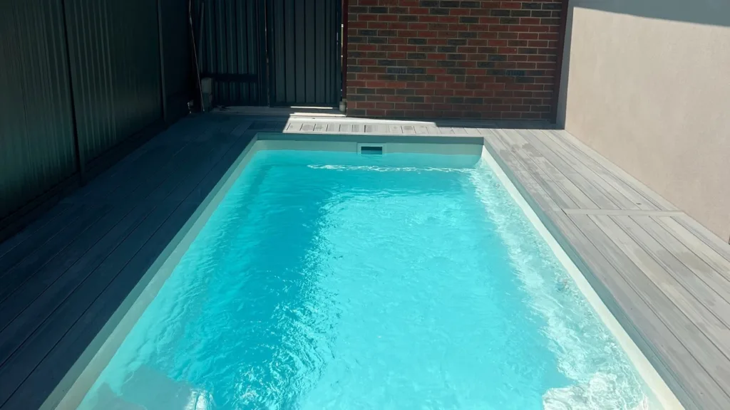 Large outdoor pool with lounge chairs and fenced yard