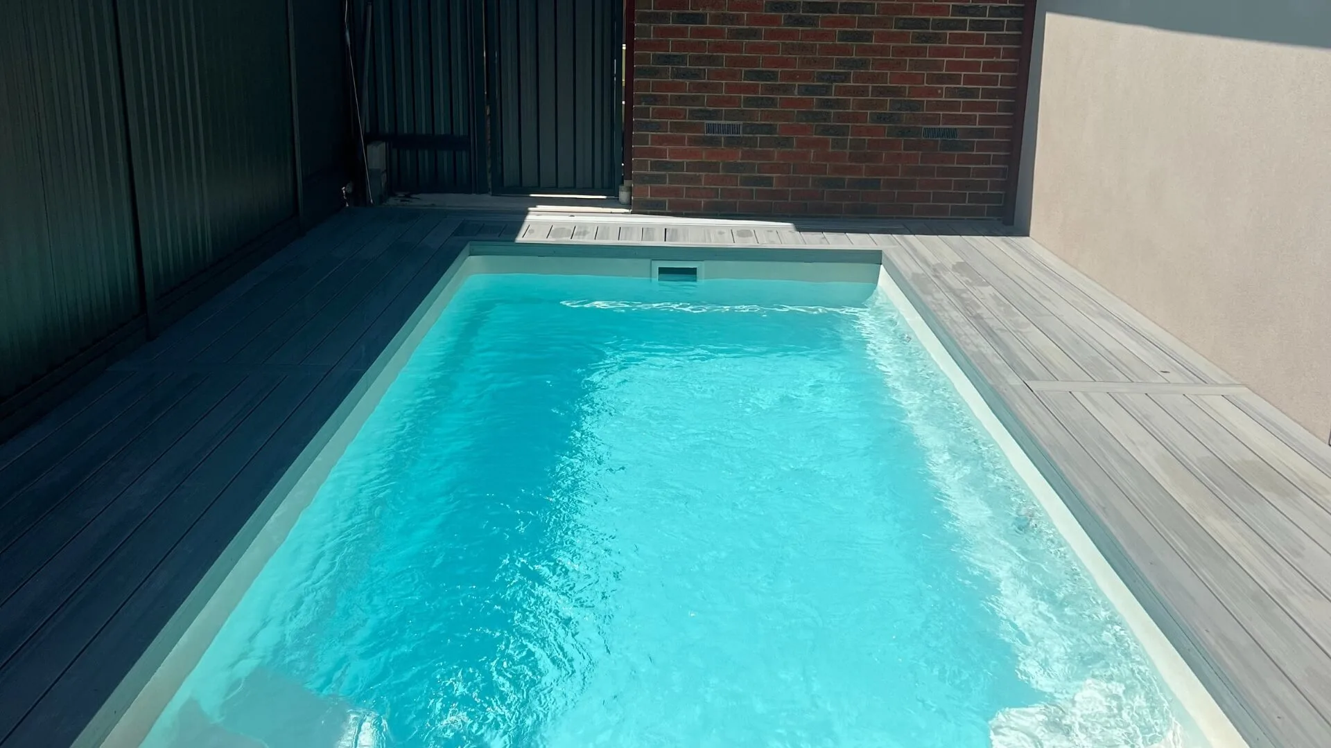 Large outdoor pool with lounge chairs and fenced yard