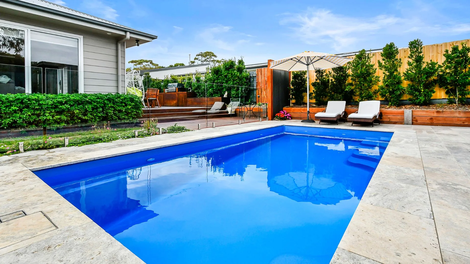 Private garden pool with deck chairs and landscaped yard